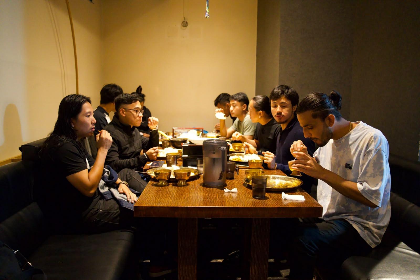 The group eating together around a low wooden table