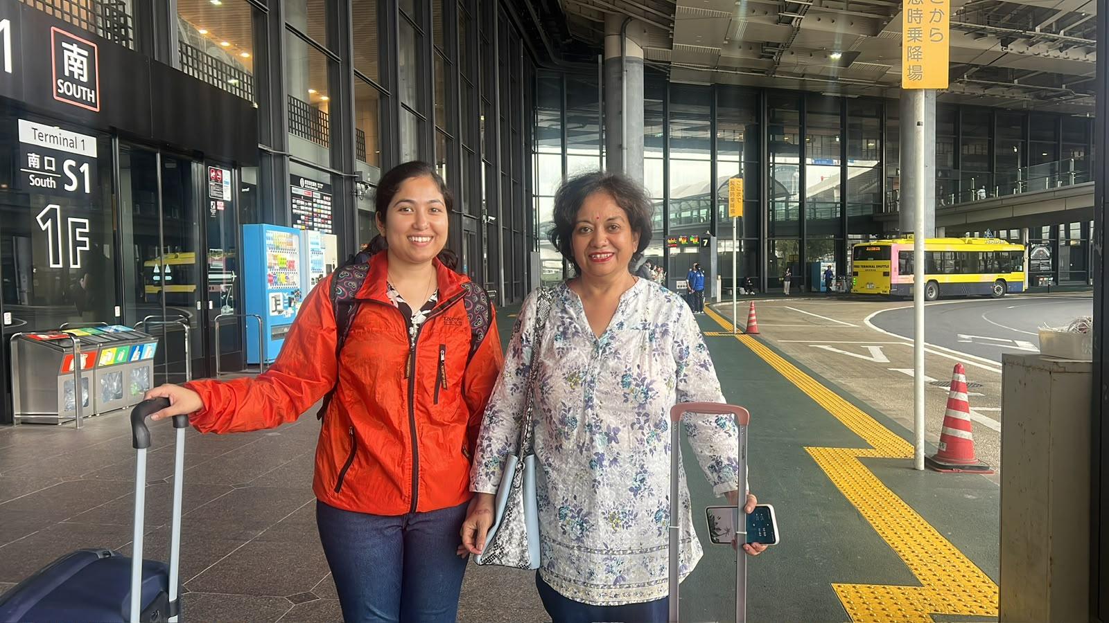 A mother and daughter with suitcases outside Narita Airport Terminal 1