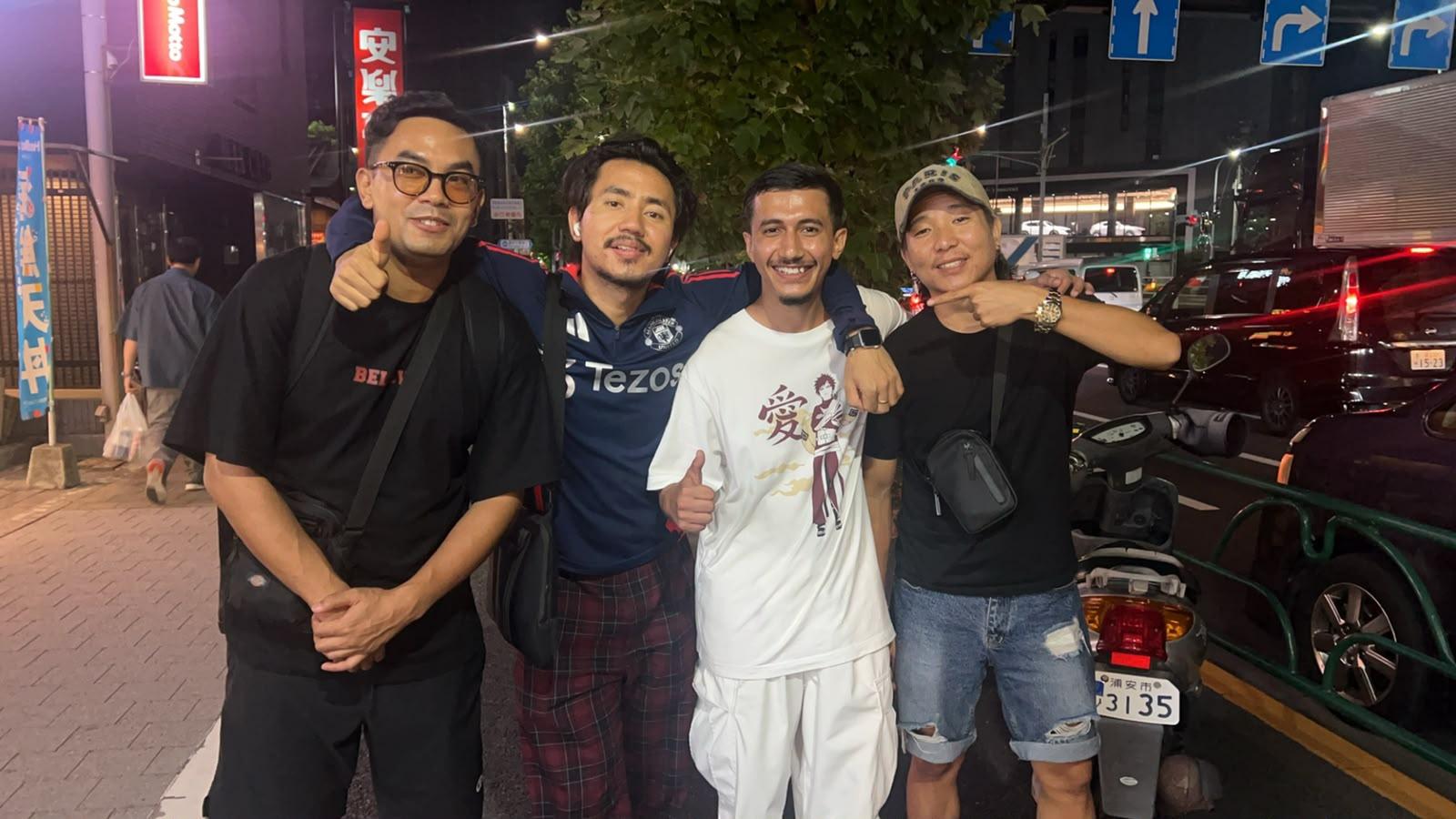 Four travellers on a Japanese street at night